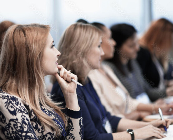 women in the audience listening and taking notes