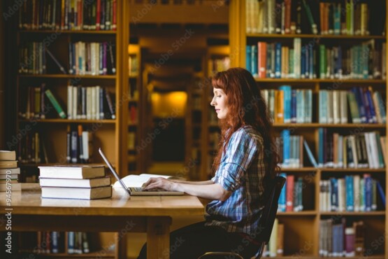 woman sitting on her laptop in a library