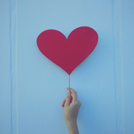 herzförmiges Schild, hochgehalten von einer Hand